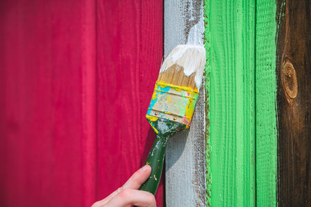 painting the door of a wooden house in a bright purple, pink, fuchsia, viva magenta color. country house, country lifeの写真素材