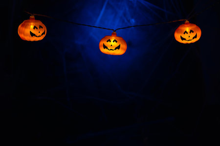 Garland with orange pumpkins on the background of cobwebs. with copy space. Halloween card backgroundの写真素材