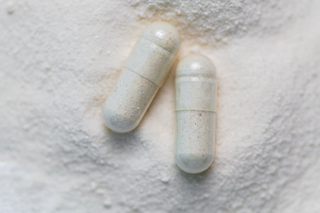 collagen in tablets and powder on wooden white background. Natural beauty and health supplement. Flat lay, top viewの写真素材