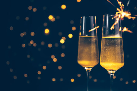 Two glasses of champagne with sparklers on bokeh background.の写真素材