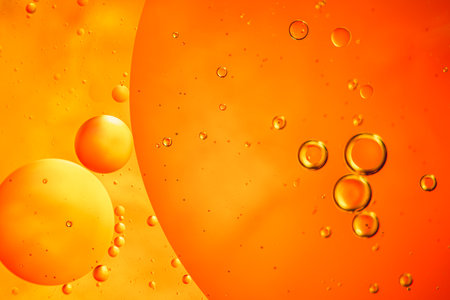 Abstract orange colorful background with oil on water surface. Oil drops in water abstract...