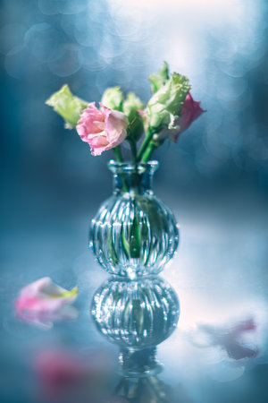 glass vase filled with a mixture of pink and green flowers, beautiful background with highlights of different colors and bokeh, creative delicate card, postcard for birthday, wedding, mother's dayの写真素材