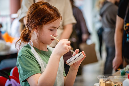 cute teen girl at a master class making a craft from wood, exhibition of crafts, crafts fair, education, master classes, DIY wood productの写真素材
