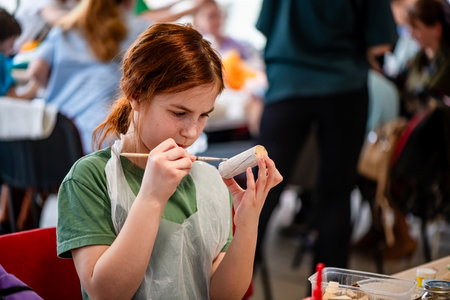 cute teen girl at a master class making a craft from wood, exhibition of crafts, crafts fair, education, master classes, DIY wood productの写真素材