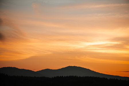 mountains covered with forest, beautiful sunset, reflection in water, wallpaper with a beautiful evening landscape, with copy spaceの写真素材