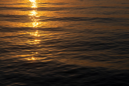 sea background, sunset or sunrise on the sea, a path of light on the water on dark sea background,...