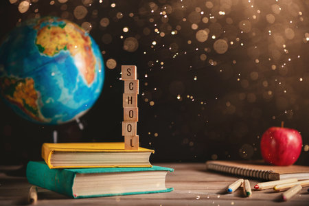 Books, globe, apple and stationery lie on the table against the chalkboardof a black blackboard. Education, September 1, new academic year with copy spaceの写真素材