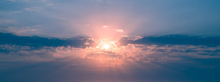 Beautiful sunset or sunrise, sky with clouds, sun rays breaking through the clouds, magical, fabulous natural background, serenity and calmの写真素材