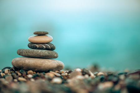 A pyramid of stones on a pebble beach by the sea, the concept of balance, calm, tranquility, relaxation with copy spaceの写真素材