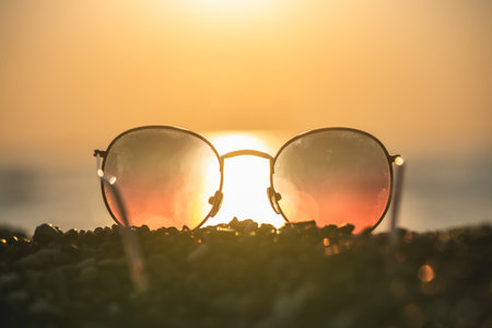 Sunglasses on the background of the sea at sunset, concept summer vacation at the seaの写真素材