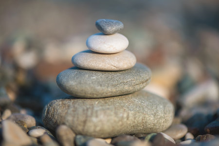 A pyramid of stones on a pebble beach by the sea, the concept of balance, tranquility, relaxationの写真素材