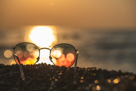 Sunglasses on the background of the sea at sunset, concept summer vacation at the seaの写真素材
