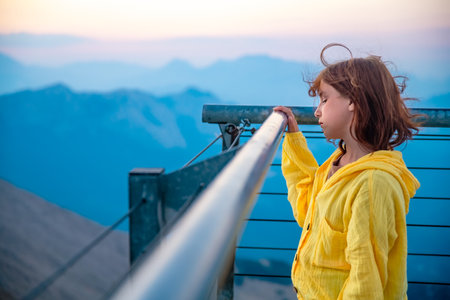 Cute girl on sports equipment in the yard of the house, physical activity, outdoors, in the background there is a playgroundの写真素材