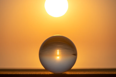 Round glass ball, in the ball sunset on the sea, concept summer, vacation, travel, vacation by the seaの写真素材