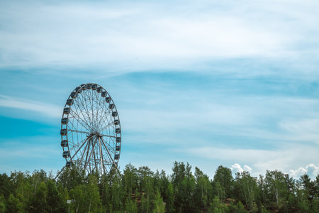 Ferris wheel with cabins against the background of the sky and clouds, amusement park with copy spaceの写真素材