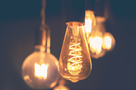 Spiral Retro LED light bulbs hanging on a dark background in interior. Electricity, Vintageの写真素材