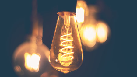 Spiral Retro LED light bulbs hanging on a dark background in interior. Electricity, Vintageの写真素材