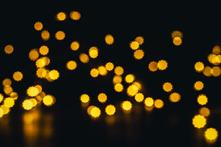 background, texture. Yellow round bokeh stars on black backgroundの写真素材