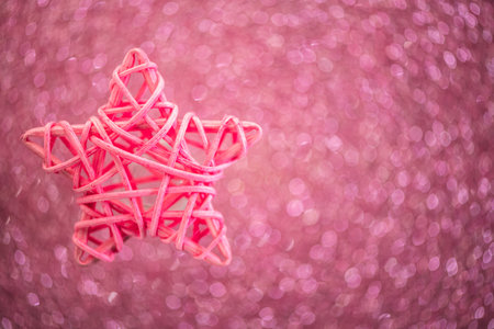 Pink wicker star on shiny pink background, with copy space, holiday, new year, christmasの写真素材