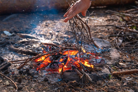 lighting a fire during a hike, throwing brushwoodの写真素材