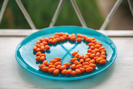 ripe orange sea buckthorn berries on a blue plate, healthy food full of vitaminsの写真素材