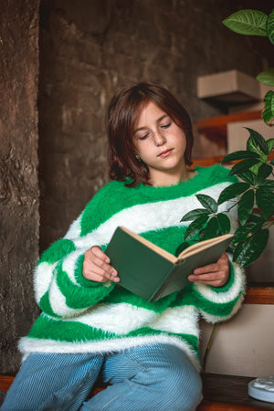 Cute Girl With Book Sitting On Stairs, Home, Coziness, Reading, Calm And Peaceの写真素材