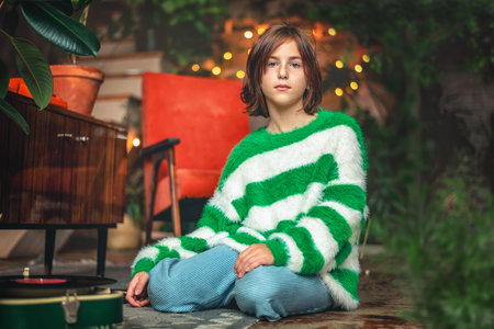 Cute girl sitting next to gramophone for vinyl records, retroの写真素材