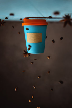 conceptual creative photography of coffee in a takeaway blue mockup cup, with copy space. inverted composition, falling coffee beansの写真素材