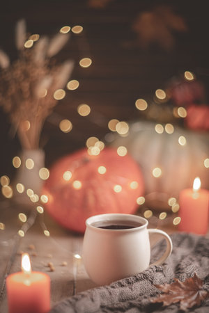 Autumn cozy composition. Tea in a mug, pumpkins and candlesの写真素材