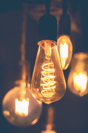 Spiral Retro LED light bulbs hanging on a dark background in interior. Electricity, Vintageの写真素材
