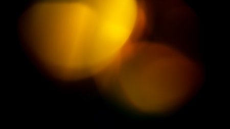 orange golden warm bright highlights on a black background. for overlay to create effect of sun rays on a bright day, warm, cozy atmosphereの写真素材