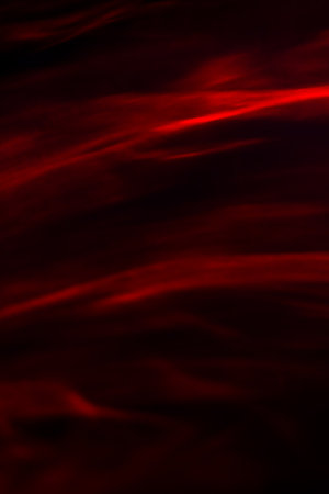 Defocused abstract red background of speed camera movement over glowing lights. A pattern of flashes...