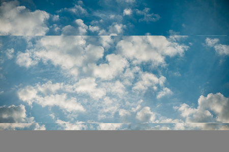 Beautiful white clouds drift lazily across a vibrant blue sky, creating a picturesque scene of tranquility and natural beauty, nature background wallpaperの写真素材