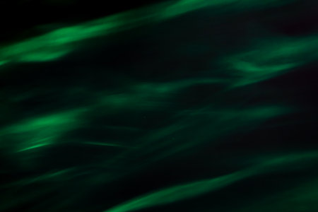 Defocused abstract green background of speed camera movement over glowing lights. A pattern of flashes of light similar to the northern lights. for overlayの写真素材