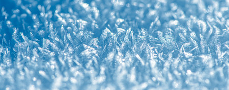 Close-up view of glistening snow crystals forming a delicate winter scene against a serene blue backdrop, background, capturing the intricate beauty and frosty magic of nature's frozen artistryの写真素材