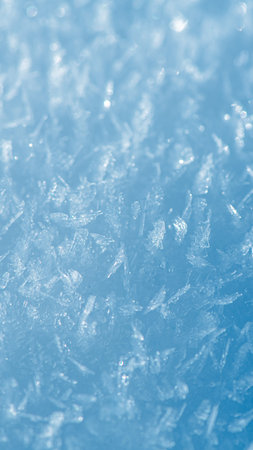 Close-up view of glistening snow crystals forming a delicate winter scene against a serene blue backdrop, background, capturing the intricate beauty and frosty magic of nature's frozen artistryの写真素材