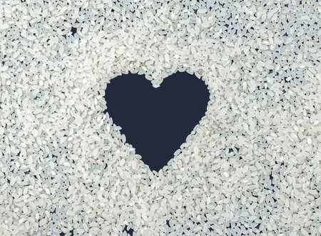 heart of white rice on a dark background. love, healthy food, valentine's day. horizontal, copy spaceの写真素材