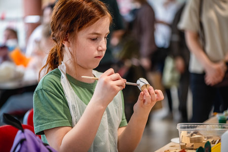 cute teen girl at a master class making a craft from wood, exhibition of crafts, crafts fair, education, master classes, DIY wood productの写真素材