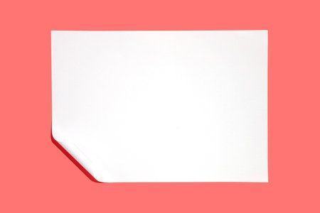 Minimalist composition featuring a pristine white sheet of paper with a gently curled corner, set against a vibrant pink backdrop, offering ample copy space for text or design elementsの写真素材