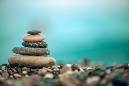 A pyramid of stones on a pebble beach by the sea, the concept of balance, calm, tranquility,...