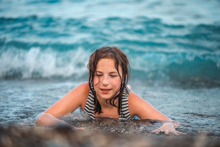 portrait of cute cheerful smiling teenage girl with freckles on sea backgroundの写真素材