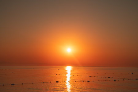 view of a bright orange sunset over the seaの写真素材
