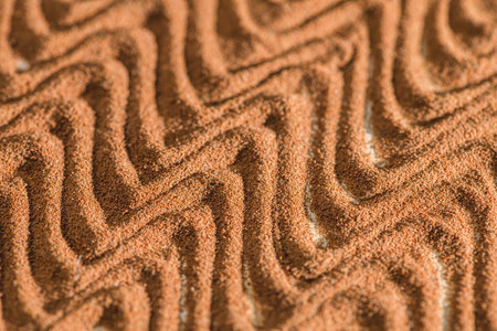 Ground chicory root forming a wavy pattern creates an intriguing texture, showcasing rich brown color and fine granules of a popular caffeine-free coffee substituteの写真素材