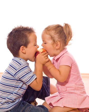 Little boy and girl bite an appleの写真素材