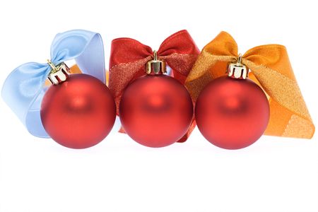 Three red christmas balls with assorted colorful ribbons - over whiteの写真素材