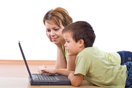Child surfing the net under supervision - isolated, focus on the boy faceの写真素材