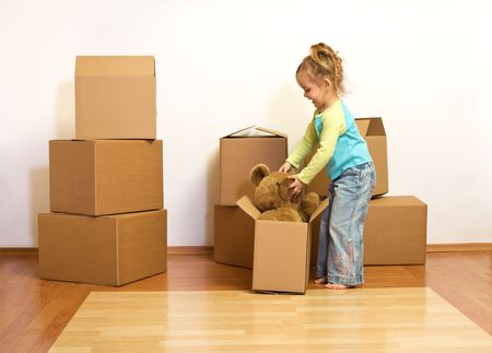 Excited little girl with cardboard boxes, unpacking in her new homeの写真素材