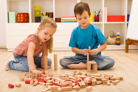 Little builders - boy and girl playing with wooden blocksの写真素材