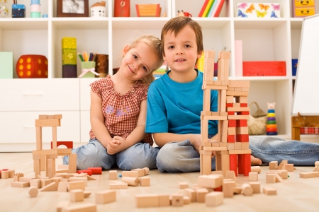 Kids in their room playing with wooden blocksの写真素材