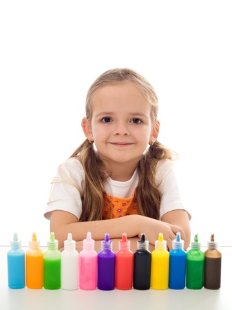 Little girl smiling at the table with her coloring kit in a row of small bottles - isolatedの写真素材